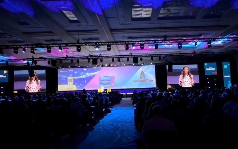 Female tech speaker Katie Linendoll speaking to a packed conference audience